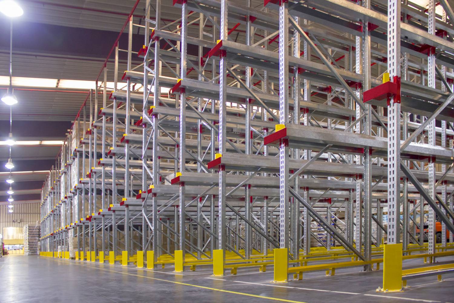 Racks penetrables Drive-In de 7,3 m de altura con 864 posiciones instalados en depósito de empresa plástica, vista frontal de las baterías.