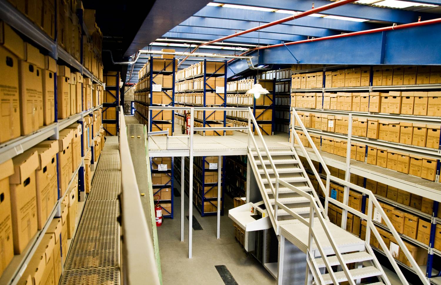 Racks de carga manual con entrepiso y escalera de acceso para archivo de documentación en depósito de Federación Patronal.