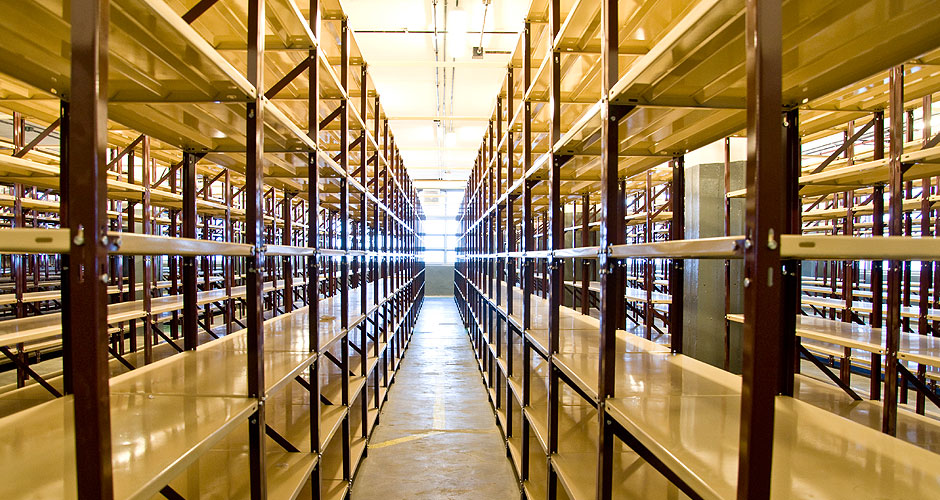 Pasillo entre racks de carga manual de doble nivel para almacenamiento de documentación de Federación Patronal.