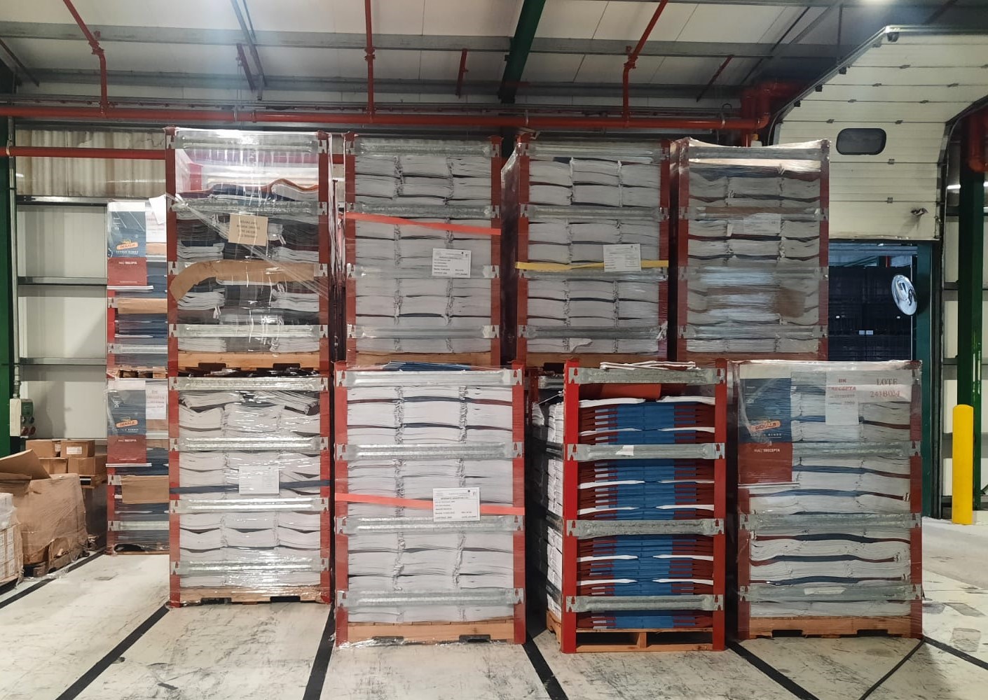 Conte-Racks apilables con productos de empaque de Monsanto almacenados en interior de depósito.